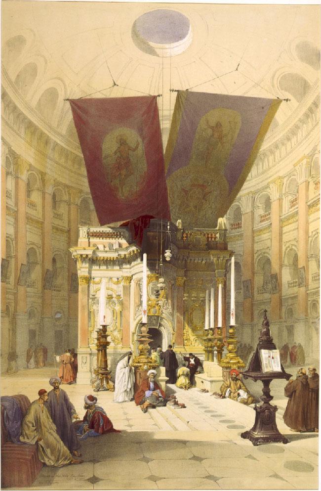 An image of the inside of a building is shown. At the top, the beige ceiling is domed with archways lining the bottom of the dome and a circular opening showing in the middle. The walls going down from the dome are beige and show three rows of arched opening, with brown posts in between each archway. Two large banners hang down from the ceiling, one is red and one is purple, both with a gold image of a figure in a loincloth with a halo on their head and holding up their arms. The purple banner on the right also has gold designs across the bottom half. Below the banners an intricately carved stone structure stands with gold edges and a large arched doorway in the middle. Lanterns hang down from the ceiling in front of the doorway. Three rows of enormous candles stand in front of the structure on gold colored candle holders. People in various robes and headdresses are seen walking, sitting, and kneeling on the floor and benches throughout the image. A large brown book stand can be seen in the right forefront of the image holding two very large books with red tassel bookmarks. The floor is white squares with circles at the edges and in the middle of some tiles.