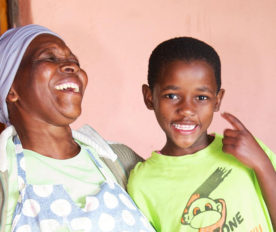 An older person holds a child who appears to be about five years old.