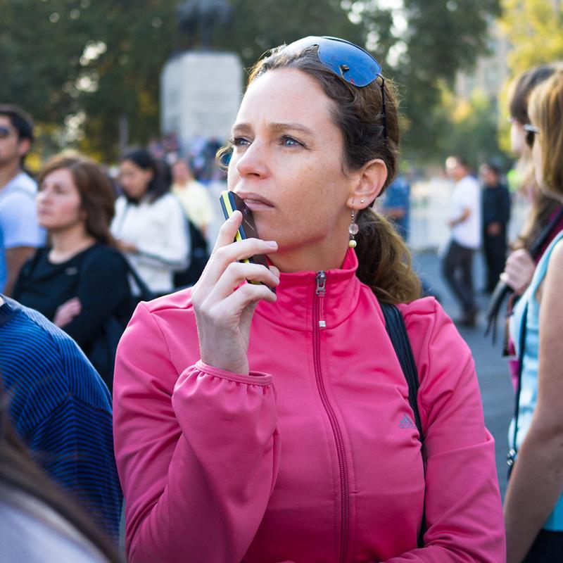 A standing woman looks pensively into the distance.