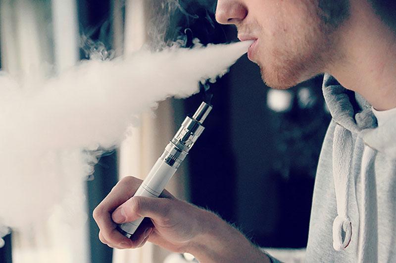 A person uses a vaping device.