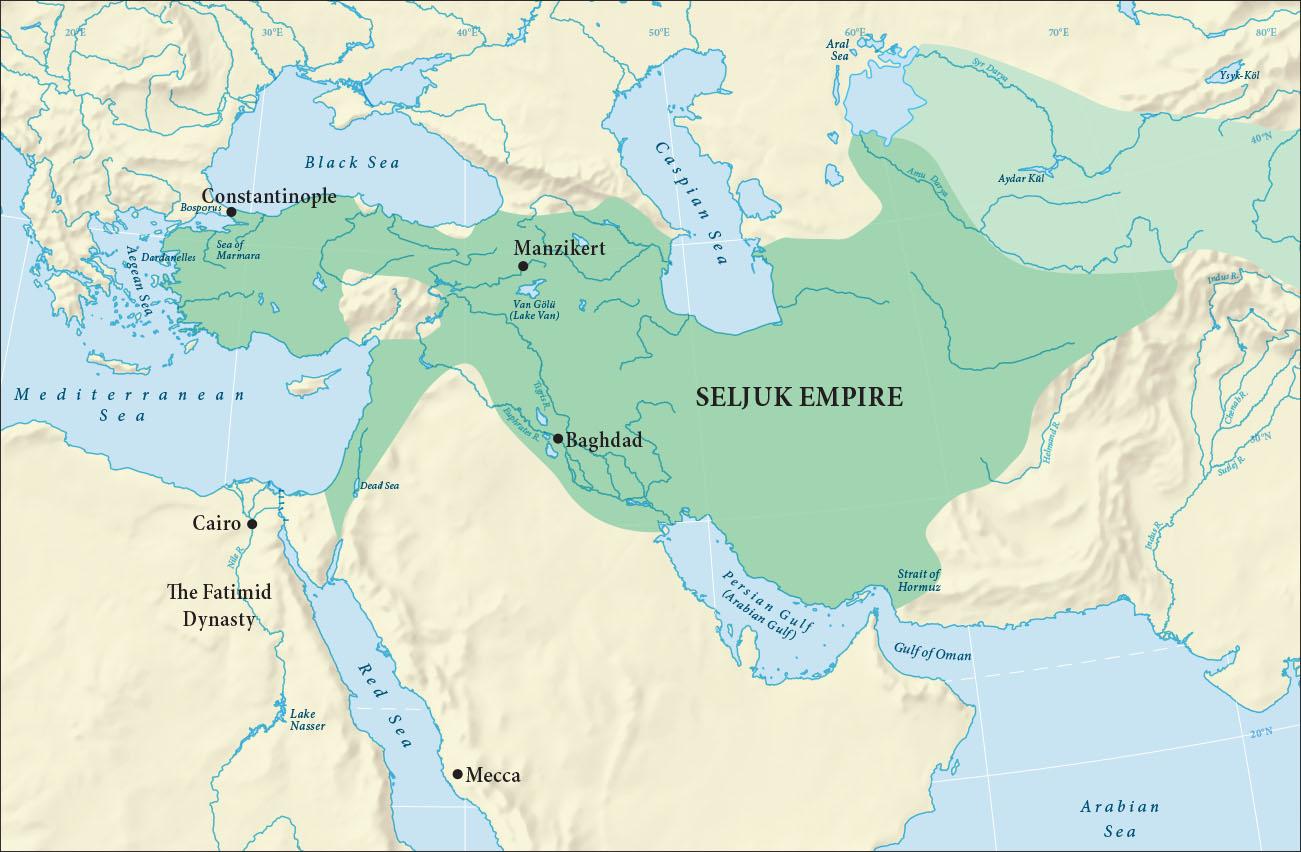 A map of land highlighted beige and water highlighted blue is shown. The Black Sea, the Caspian Sea, the Aral Sea, Aydar Kul, Ysyk-Kol, the Syr Darya River, and the Anu Daryu River are labelled in the north. The Aegean Sea, the Sea of Marmara, the Mediterranean Sea, and the Dead Sea are highlighted in the west while the Nile River, Lake Nasser, the Red Sea, the Persian Gulf (Arabian Gulf), the Strait of Hormuz, the Gulf of Oman, and the Arabian Sea are labelled in the south. In the middle of the map Van Golu (Lake Van), the Tigris River, and the Euphrates River are labelled. In the eastern part of the map the Indus River, the Chenab River, the Sutlej River, and the Helmand River are labelled. In the northeastern section of the map an oval area is highlighted light green with no label. A large area of the map from the Aegean Sea in the west to east of the Caspian Sea, south to the Persian Gulf (Arabian Gulf) and along the east coast of the Mediterranean Sea is highlighted green and labelled “Seljuk Empire.” Within this area are three sections, from west to east, labelled: Constantinople, Manzikert, and Baghdad. An area west of the Red Sea is labelled “Cairo” and another one labelled “The Fatimid dynasty.” At the southeastern portion of the Red Sea an area is labelled “Mecca.”