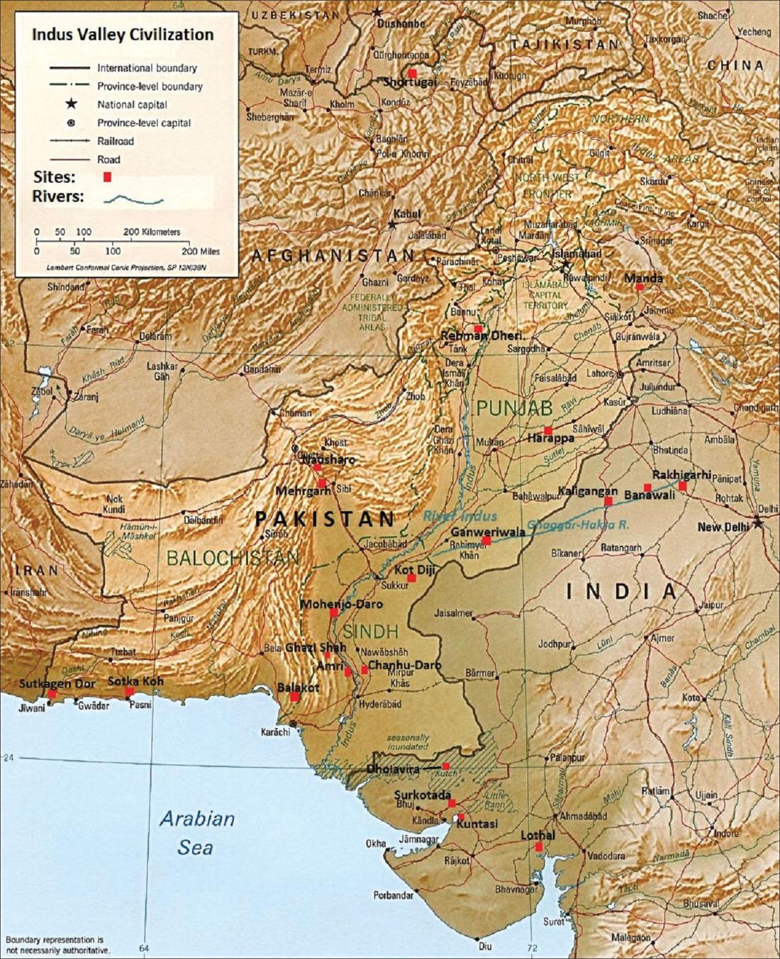 A map labelled “Indus Valley Civilization” is shown. The Arabian Sea is shown in blue in the southwest corner of the map. The rest of the map shows the following countries, from north to south: Uzbekistan, Tajikistan, China, Afghanistan, Pakistan, Iran, and India. In the legend at the top left, thick black lines indicate “International boundary,” solid black lines with a dot in the middle indicate “Province-level boundary,” black stars indicate “National capital,” a black circle with a dot in the middle indicates “Province-level capital,” black lines with tick marks on it indicate “Railroad,” and solid red lines indicate “Road.” “Sites:” are indicated with a red square and “Rivers:” are indicated with a green wavy line. A scale is shown as well in kilometers and miles and is cited with “Lambert Conformal Conic Projection, SP 12N/38N.” Gold colored areas that appear bumpy are shown on the terrain of the map north and northwest of India.