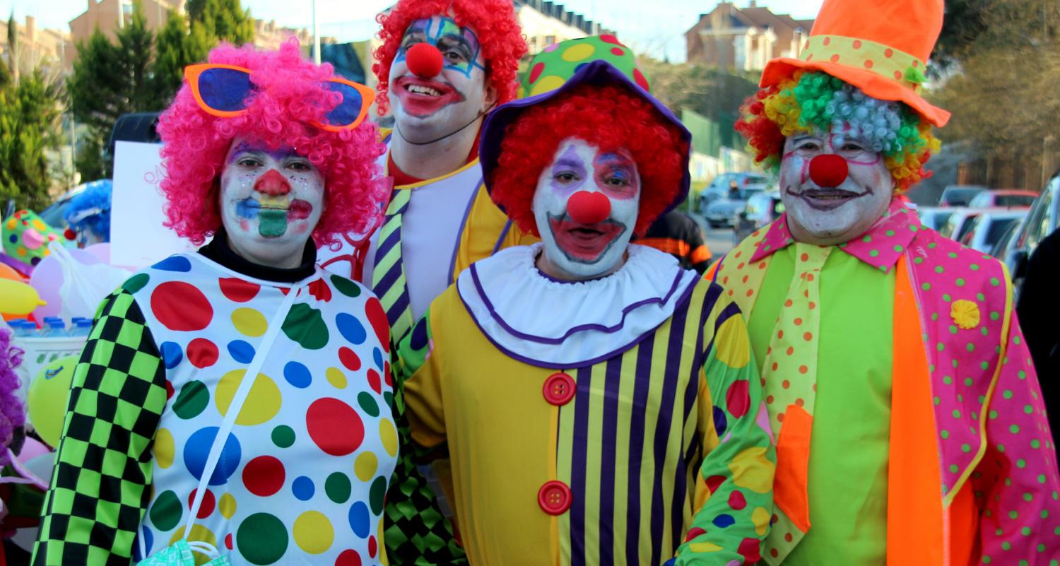 Four professional clowns standing together smiling.