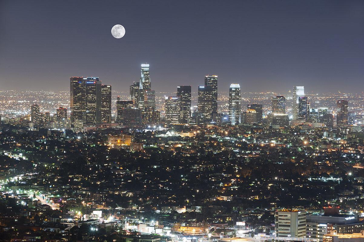 The city of Houston at night, with a full moon.